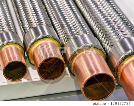 Detailed view of stainless steel and copper pipes showcasing metalwork craftsmanship and industrial design Detailed view of stainless steel and copper pipes showcasing metalwork craftsmanship and industrial design 129122787