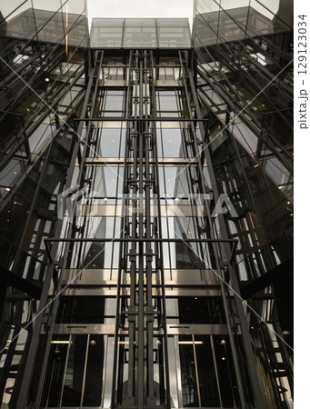the contemporary architecture featuring glass elevators within One New Change notable for its distinctive modern design. the contemporary architecture featuring glass elevators within One New Change notable for its distinctive modern design. 129123034
