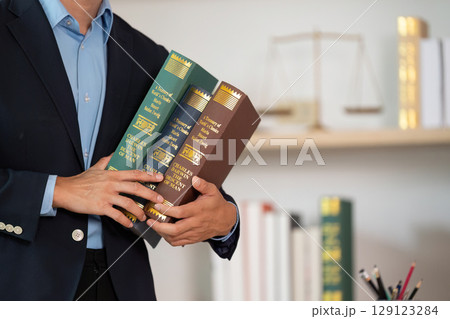 Legal Consultation. Lawyer holding law books in office. 129123284