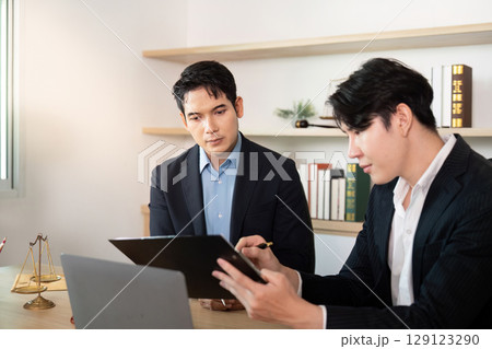 Business Meeting. Two lawyers discussing legal documents in office. 129123290