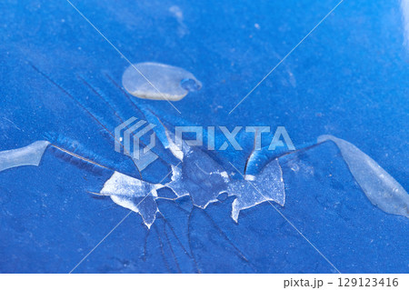 Close up of cracked blue paint surface with fragmented patterns and peeling Close up of cracked blue paint surface with fragmented patterns and peeling 129123416