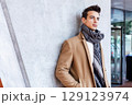 Stylish young man in coat and scarf outdoors 129123974