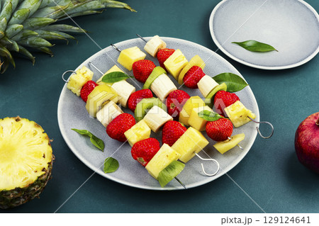 Fruits on skewers, dessert. 129124641