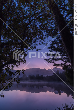 ニュージーランド　早朝の霧がかったレイク・マセソンから見えるマウント・クックと朝焼け空 129124957