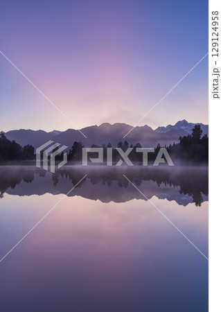 ニュージーランド　早朝の霧がかったレイク・マセソンから見えるマウント・クックと朝焼け空 129124958