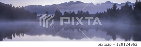 ニュージーランド　早朝の霧がかったレイク・マセソンから見えるマウント・クックと朝焼け空 129124962