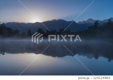 ニュージーランド　早朝の霧がかったレイク・マセソンから見えるマウント・クックと昇る太陽 129124965