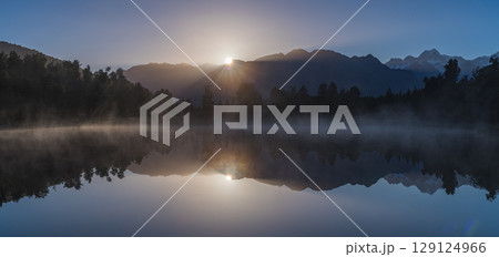 ニュージーランド　早朝の霧がかったレイク・マセソンから見えるマウント・クックと昇る太陽 129124966