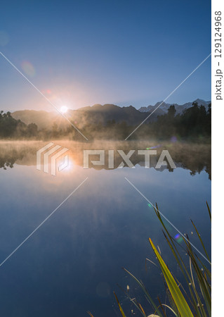 ニュージーランド　早朝の霧がかったレイク・マセソンから見えるマウント・クックと昇る太陽 129124968