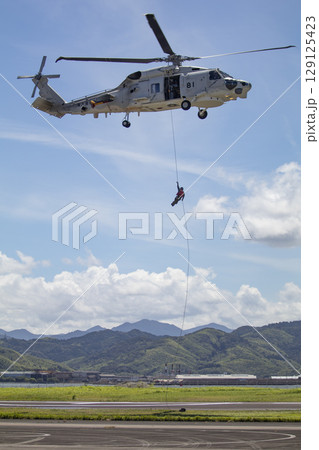 ヘリコプターからホイスト降下する隊員 129125423