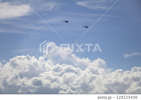 夏雲の上を飛ぶヘリコプター 129125430