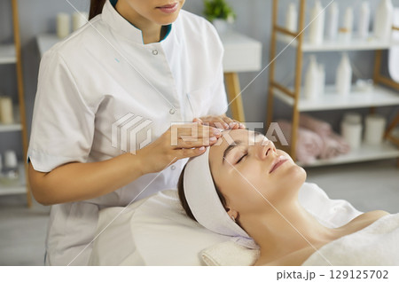 Facial massage by beautician in modern spa clinic 129125702
