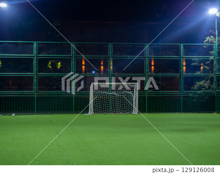 Football ground in the evening. Artificial lawn. Available infrastructure. Empty sports ground. Football game concept. Sports mesh. Entertainment in the park. Under the lanterns Football ground in the evening. Artificial lawn. Available infrastructure. Empty sports ground. Football game concept. Sports mesh. Entertainment in the park. Under the lanterns 129126008