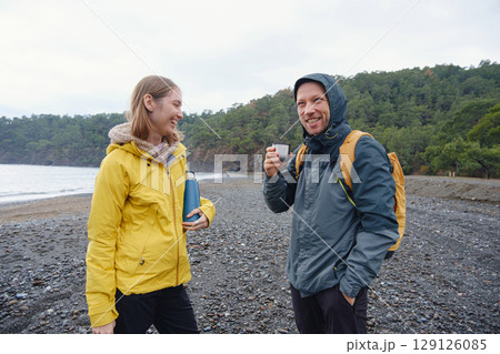 Couple drinks tea by winter sea shore 129126085