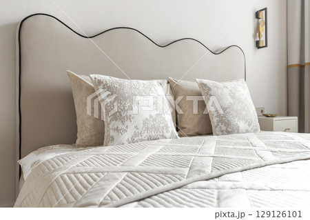 Elegant Bed Headboard with Decorative Pillows in Neutral Tones 129126101