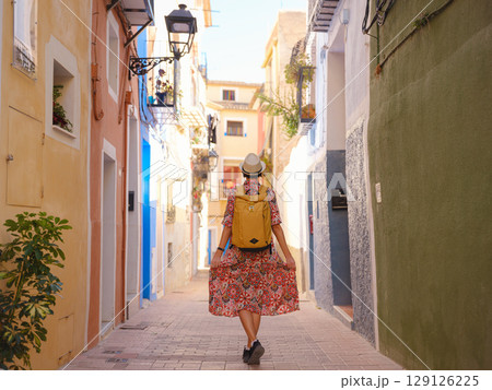 Woman strolls through colorful streets of Spanish coastal town 129126225