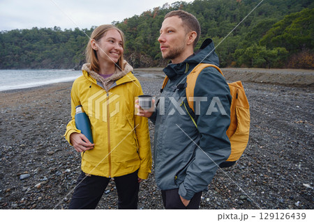 Couple drinks tea by winter sea shore Couple drinks tea by winter sea shore 129126439
