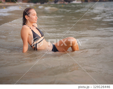 Young woman enjoying serene evening at sea in Krabi, Thailand Young woman enjoying serene evening at sea in Krabi, Thailand 129126446