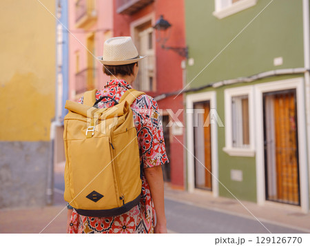 Woman strolls through colorful streets of Spanish coastal town 129126770