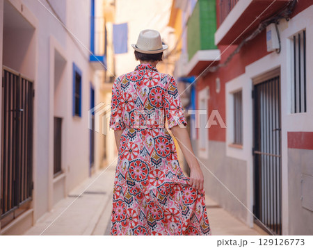 Woman strolls through colorful streets of Spanish coastal town 129126773