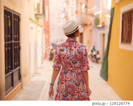 Woman strolls through colorful streets of Spanish coastal town Woman strolls through colorful streets of Spanish coastal town 129126774
