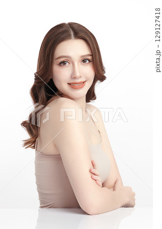 A beautiful young Asian woman with clean, fresh skin against a white background. Skincare, facial treatment, cosmetology, beauty, and spa. An elegant portrait of an Asian woman. 129127418