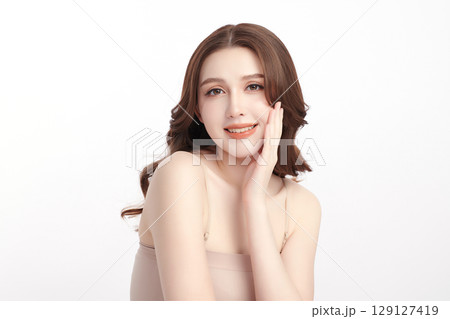 A beautiful young Asian woman with clean, fresh skin against a white background. Skincare, facial treatment, cosmetology, beauty, and spa. An elegant portrait of an Asian woman. A beautiful young Asian woman with clean, fresh skin against a white background. Skincare, facial treatment, cosmetology, beauty, and spa. An elegant portrait of an Asian woman. 129127419