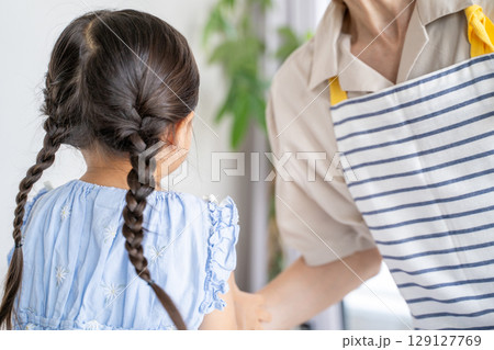 手を取り合う父親と後ろ姿の娘 129127769