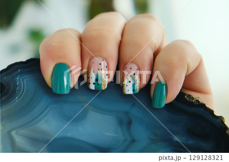 Female hands with green nail design. Female hands with green nail design. 129128321