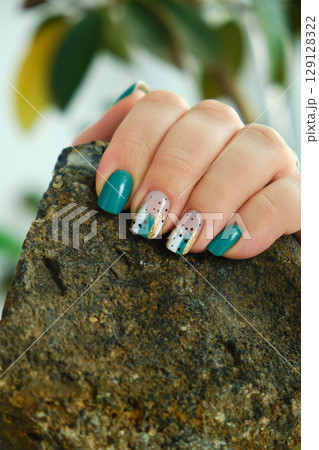 Female hands with green nail design. 129128322