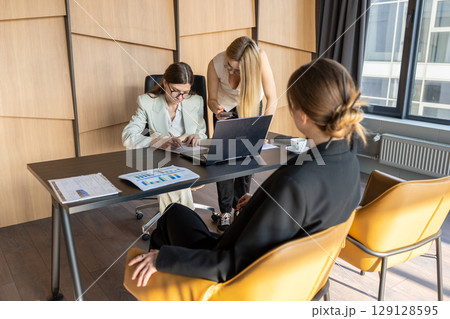 Business team of women discussing project documentation in a modern workspace Business team of women discussing project documentation in a modern workspace 129128595