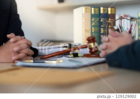 Legal Consultation. Lawyers discussing terms with hands clasped in a law office. 129129002