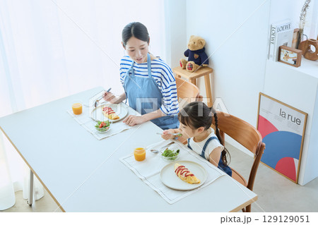 子どもの食事を見守る母と娘のあたたかい朝食 129129051