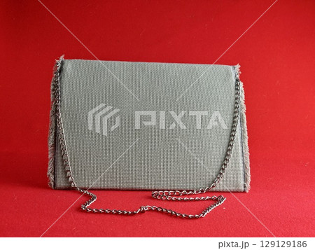 Handmade retro clutch bag on a red background. Vintage bag on chain handle. Handmade retro clutch bag on a red background. Vintage bag on chain handle. 129129186