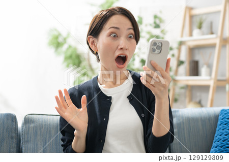 スマホを見て驚く女性 スマホを見て驚く女性 129129809