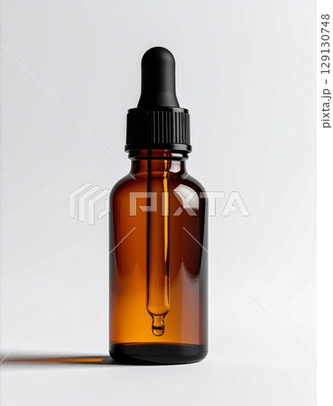 Studio Shot Of An Amber Bottle With A Black Dropper On White Backdrop 129130748