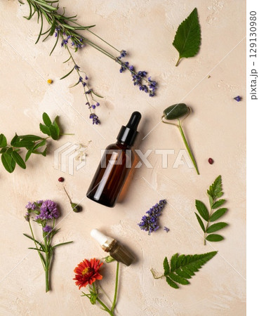 Amber Dropper Bottles and Fresh Herbs on Textured Beige Background in Flat Lay 129130980