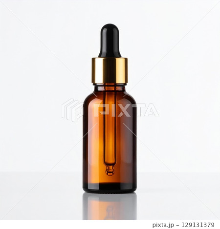 Amber Glass Serum Bottle with Golden Dropper on White Reflective Surface Amber Glass Serum Bottle with Golden Dropper on White Reflective Surface 129131379