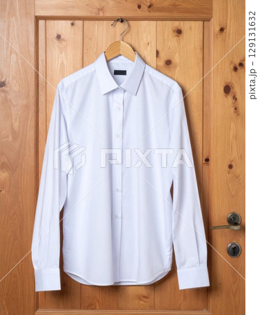 Clean White Dress Shirt Hanging on Wooden Door with Smooth Texture and Simple Style 129131632