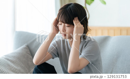 頭を押さえて悩む女性 129131753