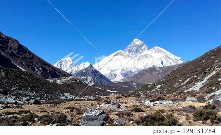 mountain landscape with snow, landscape of Mount Everest standing tall under clear blue skies. The majestic peak dominates the horizon with snow covered ridges and rugged slopes, symbolizing strength mountain landscape with snow, landscape of Mount Everest standing tall under clear blue skies. The majestic peak dominates the horizon with snow covered ridges and rugged slopes, symbolizing strength 129131784