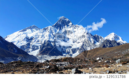 mountain landscape with snow, landscape of Mount Everest standing tall under clear blue skies. The majestic peak dominates the horizon with snow covered ridges and rugged slopes, symbolizing strength mountain landscape with snow, landscape of Mount Everest standing tall under clear blue skies. The majestic peak dominates the horizon with snow covered ridges and rugged slopes, symbolizing strength 129131786