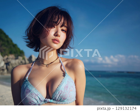海辺で佇むビキニ姿の日本人美女と青空が広がる夏のポートレート 129132174