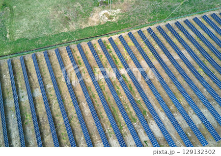 Aerial view of solar power plant on green field. Electric farm with panels for producing clean ecologic energy Aerial view of solar power plant on green field. Electric farm with panels for producing clean ecologic energy 129132302