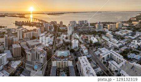 Aerial view of Sarasota city downtown at sunset with high-rise office buildings and Ringling Bridge on horizon. Real estate development in Florida. USA travel destination 129132319