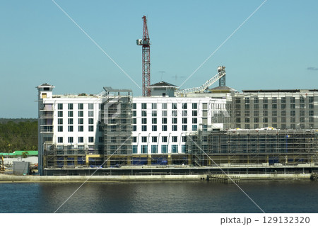 Aerial view of ruined by hurricane Ian construction crane on high apartment building site in Port Charlotte, USA 129132320