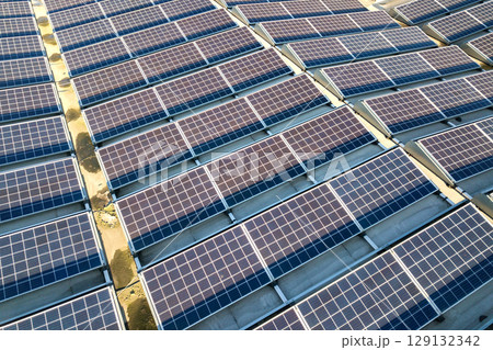 Aerial view of many photo voltaic solar panels mounted of industrial building roof. Aerial view of many photo voltaic solar panels mounted of industrial building roof. 129132342