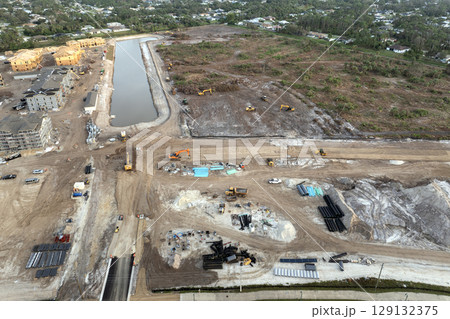 Aerial view of large construction site with building equipment on prepared soil in American rural area. Development of residential housing in US suburbs. Real estate market in the USA Aerial view of large construction site with building equipment on prepared soil in American rural area. Development of residential housing in US suburbs. Real estate market in the USA 129132375