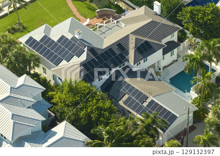 Aerial view of expensive american home with swimming pool and roof with blue solar photovoltaic panels for producing clean ecological electric energy. Renewable electricity with zero emission concept 129132397