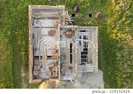 Aerial view of building site for future house, brick basement floor and stacks of brick for construction. Aerial view of building site for future house, brick basement floor and stacks of brick for construction. 129132429